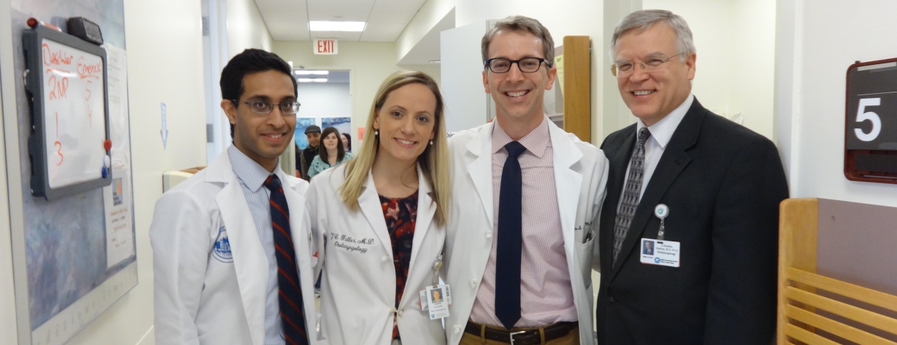 Doctor Bradley Welling at left with former trainees in hallway