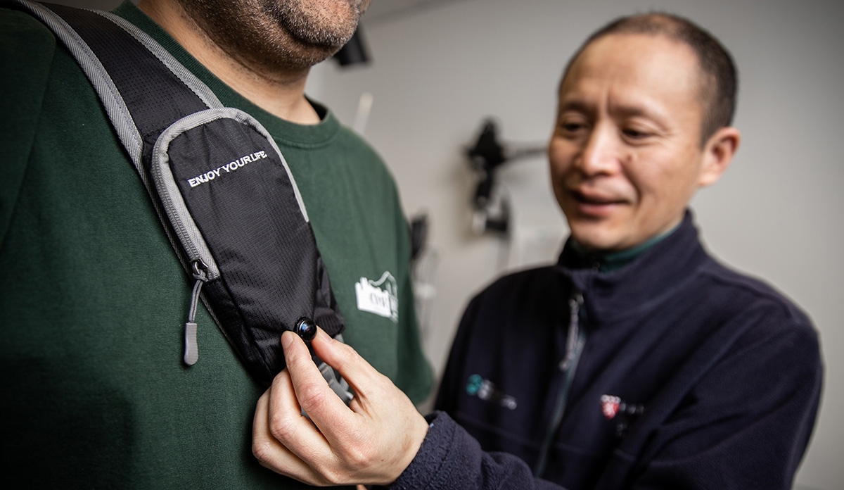 Gang Luo, PhD, displays the camera on the strap of the wearable collision device